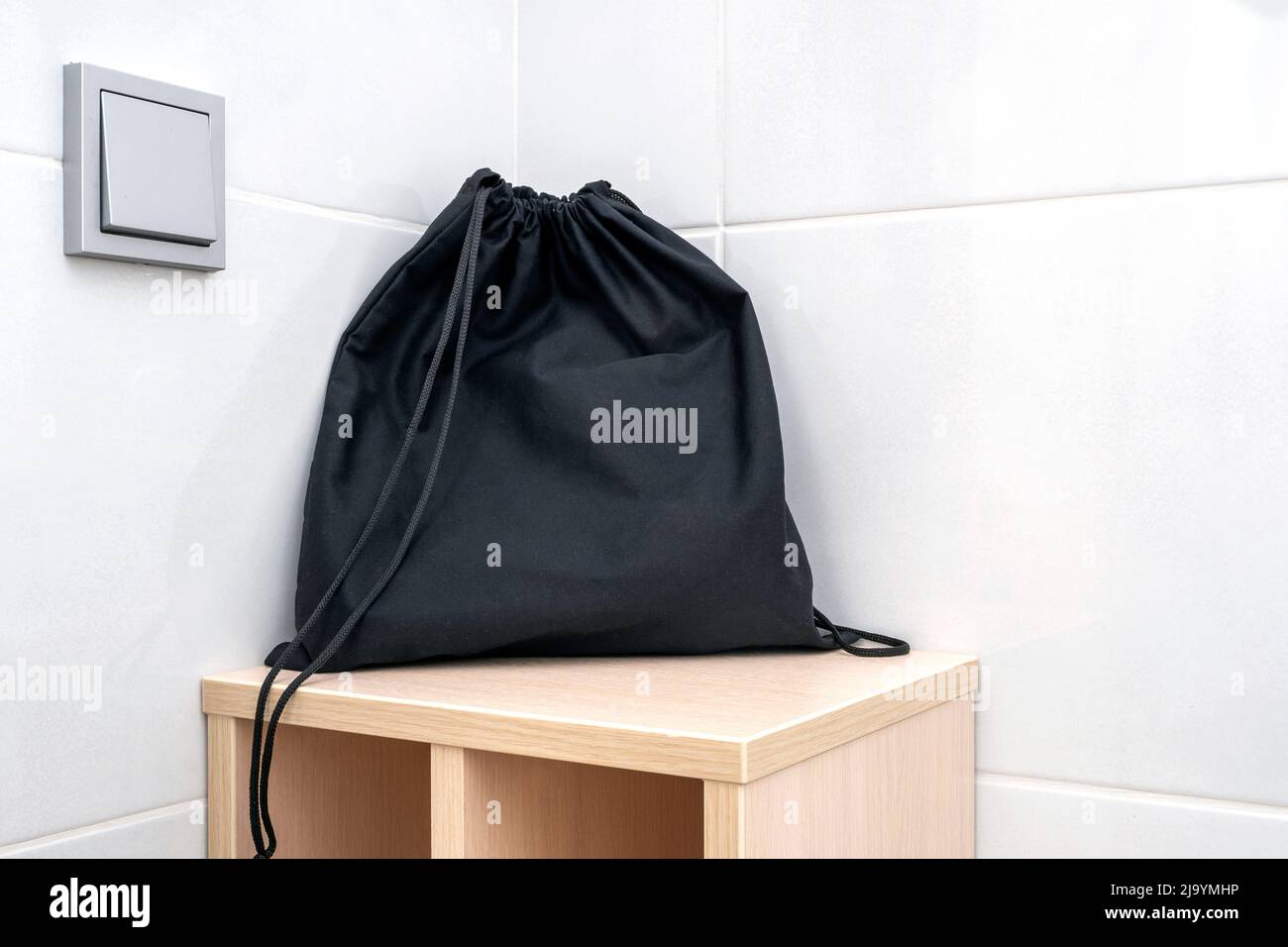 Schwarze Stofftasche auf einem Regal im Badezimmer, Tasche für die Aufbewahrung von Accessoires, Haartrockner Stockfoto