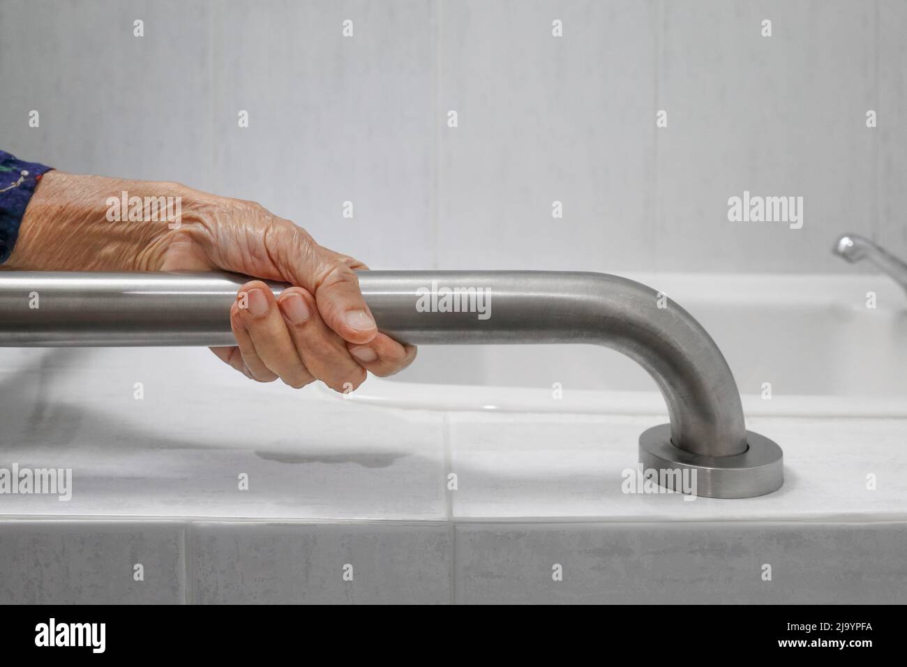 Ältere Frau, die im Badezimmer am Handlauf festhält Stockfoto