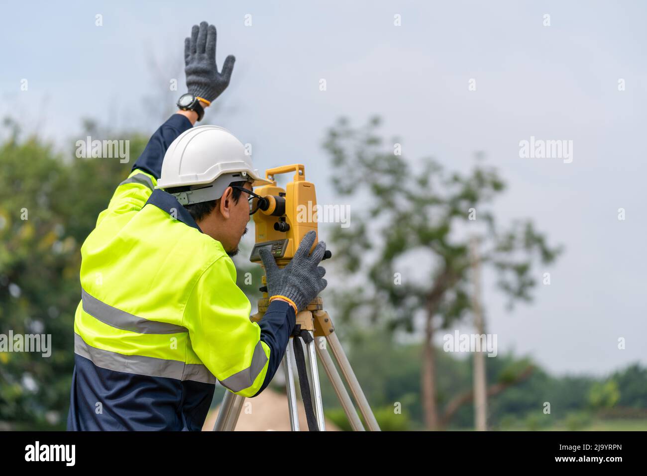 Asian Surveyor Civil Engineer, der auf der Baustelle Theodolit- oder Total Positioning Station arbeitet. Stockfoto