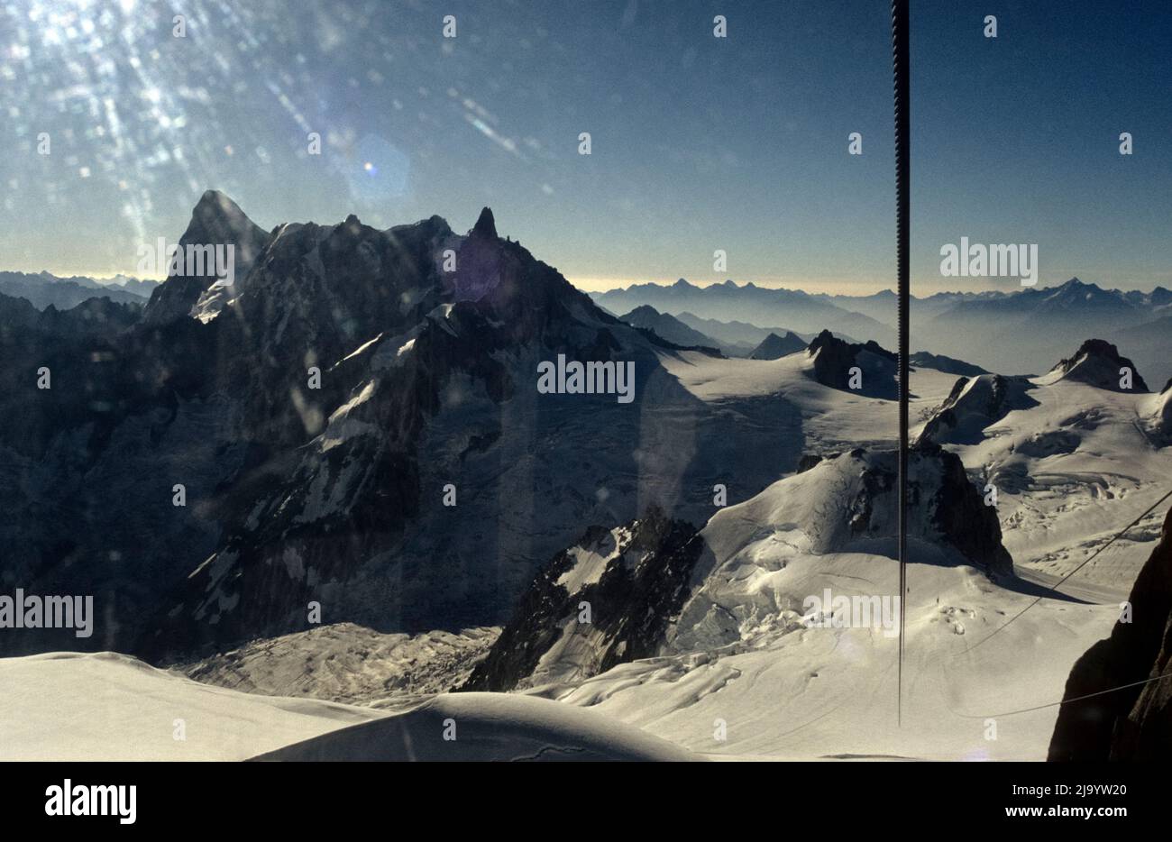 Blick von einer Gondel auf den Panorama Mont-Blanc auf Aiguille du Géant und Grandes Jorasses. Die Sonnenstrahlen werden im Fenster reflektiert. Chamonix, 1990 Stockfoto