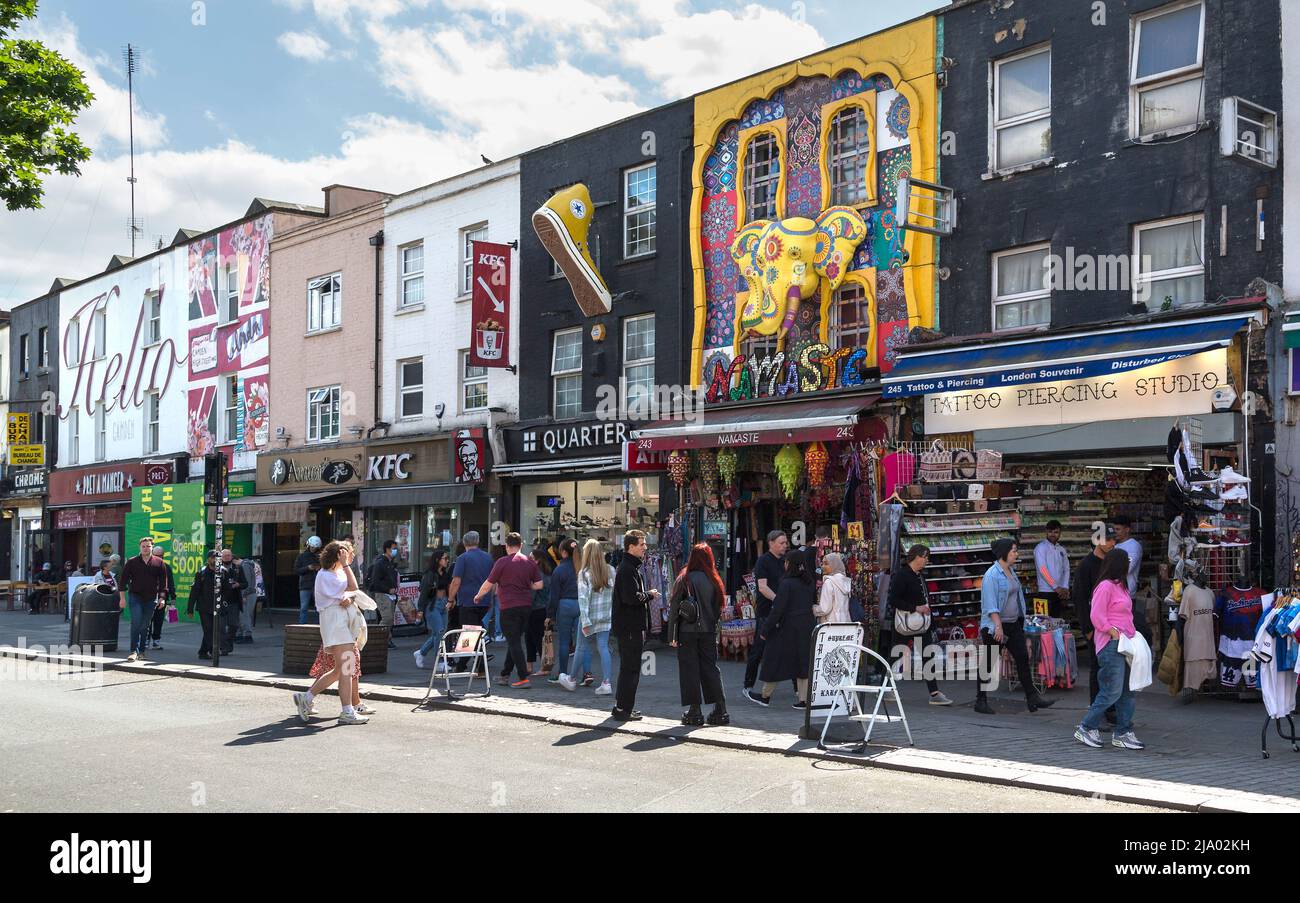 Shopper und Touristen, die entlang der Camden High Street mit ihren schrulligen, farbenfrohen und prunkvollen Geschäften gehen, Stockfoto