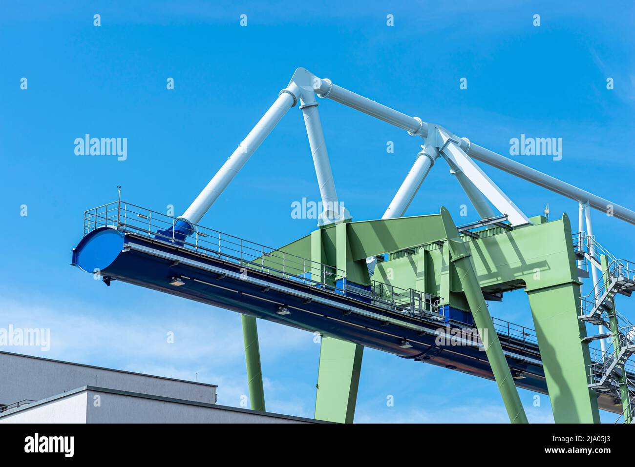 Eine massive Hafenbrücke auf Schienen, die auf dem Umladeplatz stehen, ist ein riesiges Stahltraversen sichtbar. Stockfoto