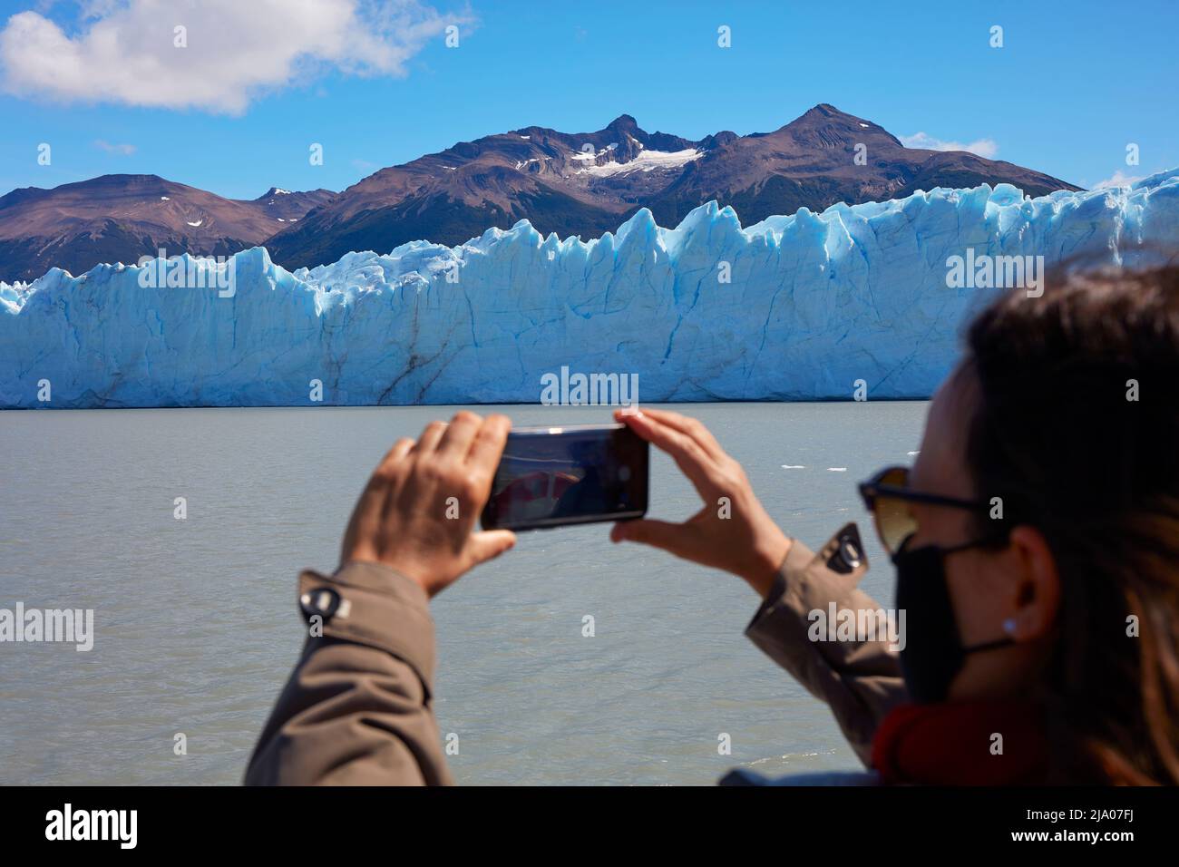 Ein Tourist, der während der Covid-Pandemie den Perito Moreno-Gletscher fotografiert, El Calafate, Santa Cruz, Argentinien. Stockfoto