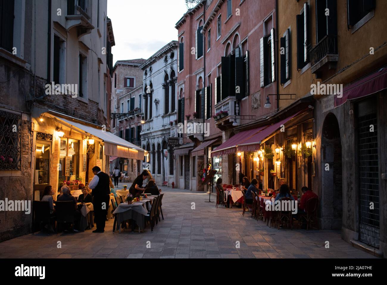 In Venedig, Italien, können Gäste in der Abenddämmerung draußen essen Stockfoto