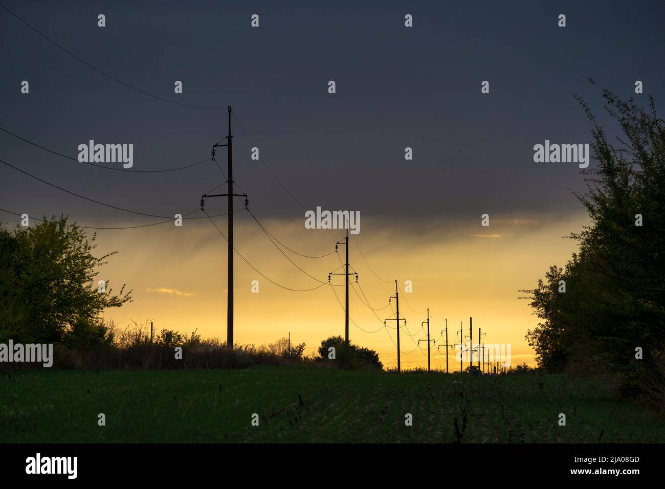 Stromleitungen bei Sonnenuntergang, Hochspannungsmast, Hochspannungsturm Himmel Sonnenuntergang Hintergrund Stockfoto