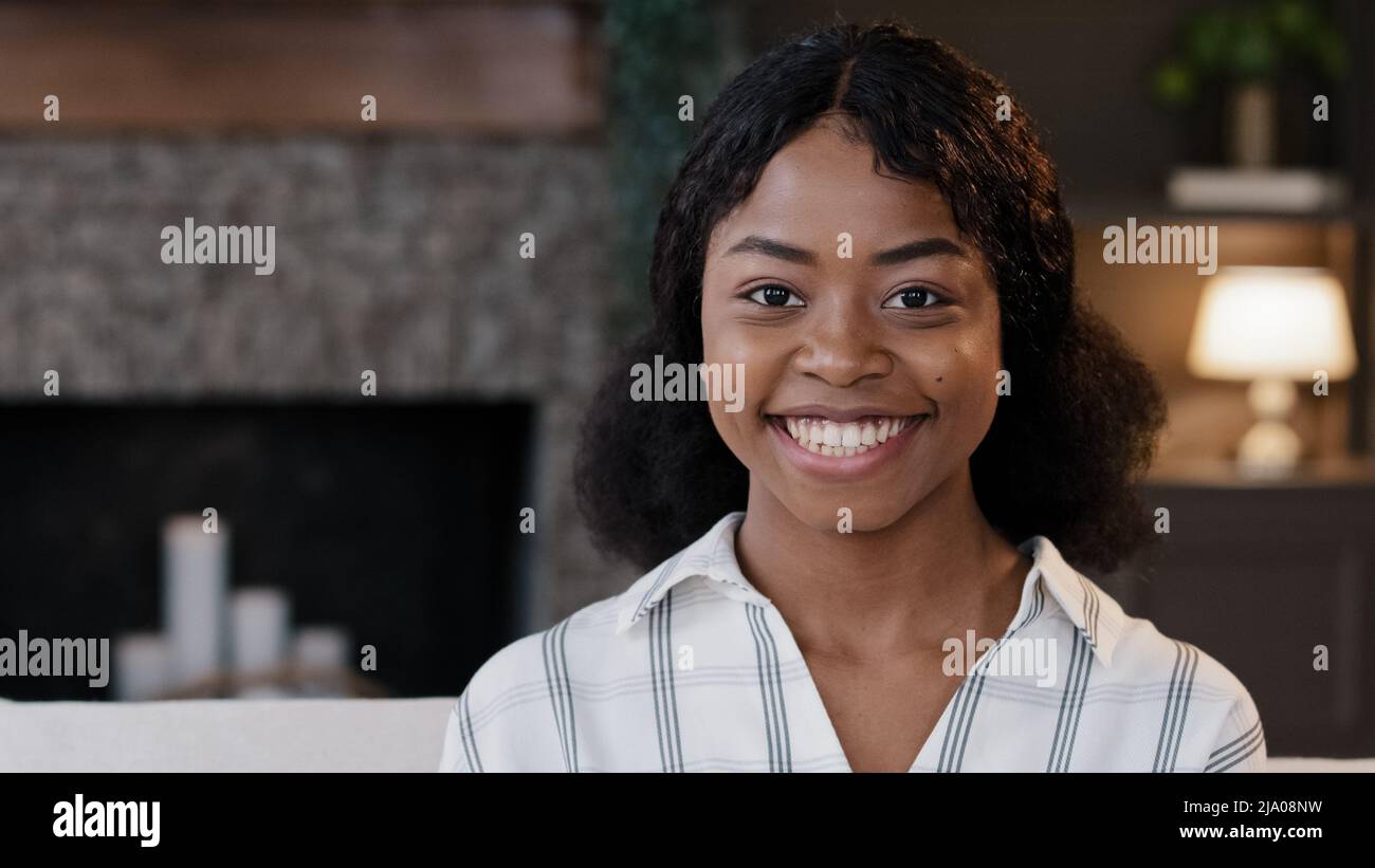 Portrait afroamerikanisch Mädchen Nahaufnahme weiblich Gesicht Modell hausfrau Frau Freundin Student Blick zur Seite zu Hause dreht Kopf schaut auf Kamera lächelnd Stockfoto