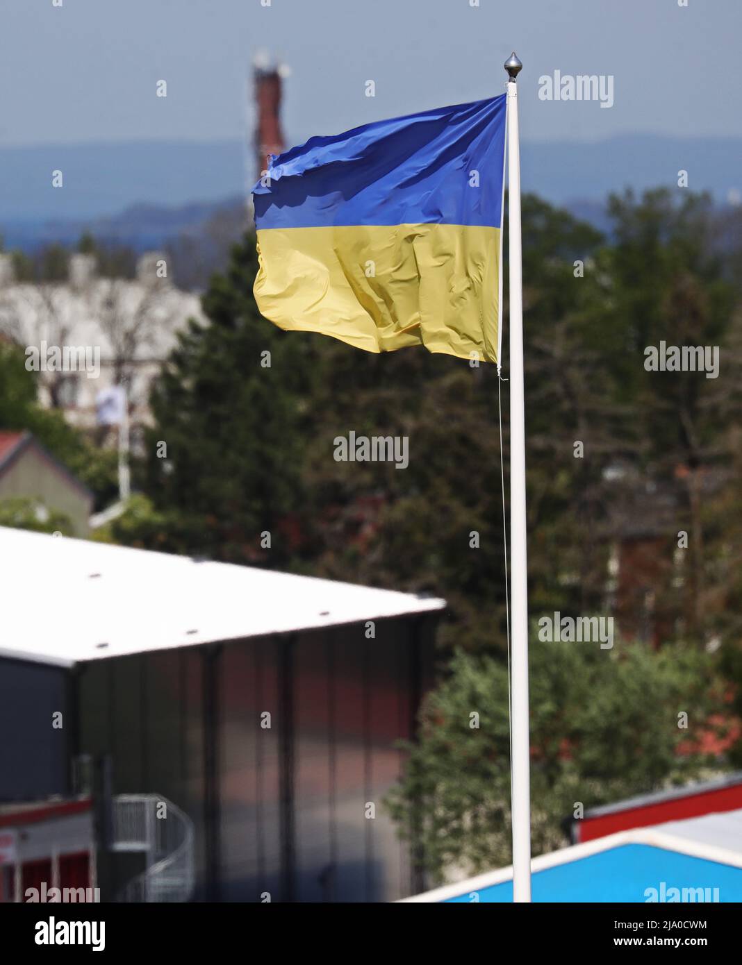 Saisonales Wetter, die ukrainische Flagge vor einem Unternehmen am Dienstag in Vadstena, Schweden. Stockfoto