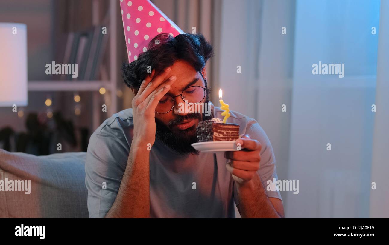 Porträt Araber traurig verärgert einsamer indischer bärtiger Mann feiert Geburtstag allein ohne Freunde fühle Traurigkeit Kopfschmerzen Scheitern männlich in festlichem rosa Hut Stockfoto