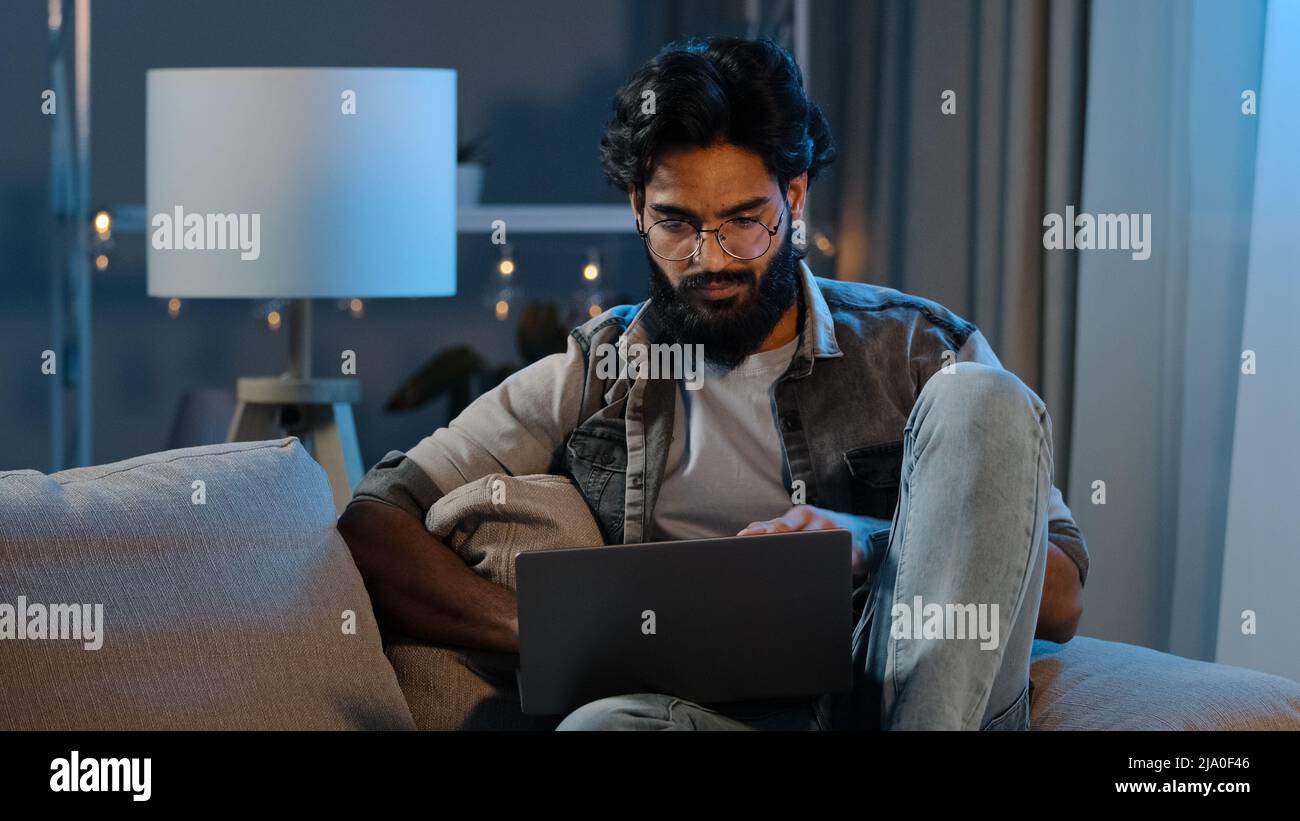 Nachdenklicher arabischer Kerl männlich freiberuflicher indischer bärtiger Erwachsener Mann, der an Computer-Projekt-Problem-Suche-Lösung denkt, die auf Laptop zu Hause sucht Stockfoto