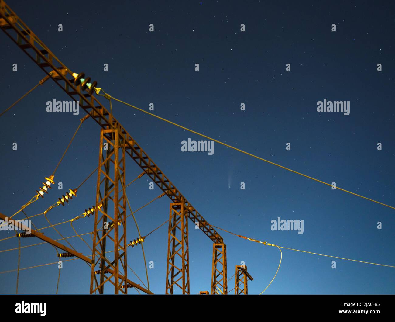 Der Komet Neowise C2020 F3 fliegt über dem Sommerhimmel über elektrischen Leitungen in Lviv City, Ukraine. Stockfoto