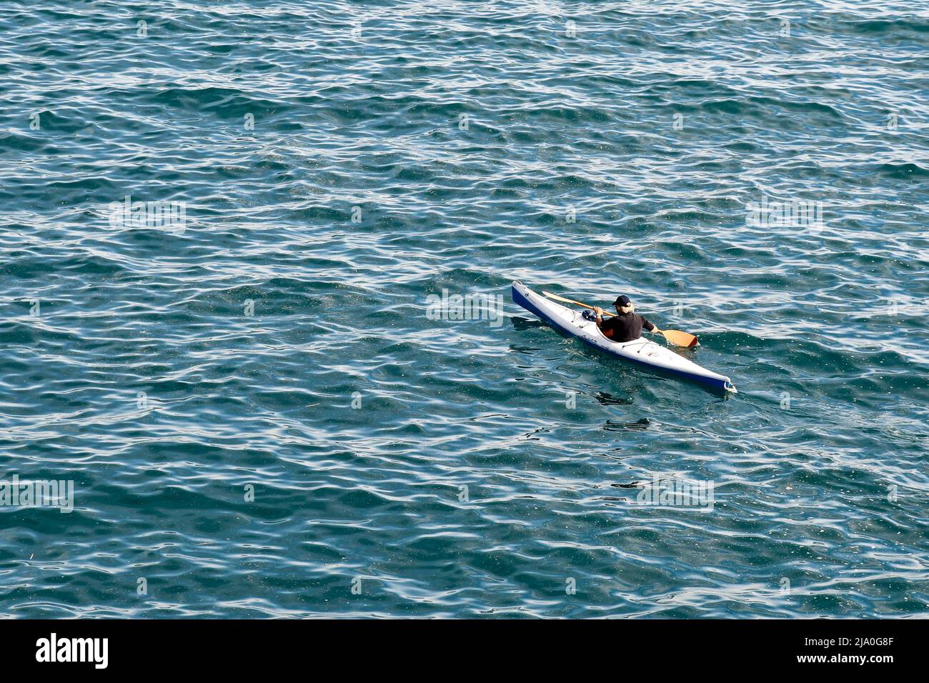 Erhöhte Ansicht eines älteren Mannes, der im Ligurischen Meer vor der Küste von Genua, Ligurien, Italien, Kajak gefahren ist Stockfoto