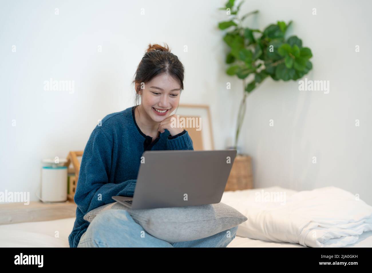 Mädchen, die von zu Hause oder von Studenten, die von zu Hause oder von Freiberuflern lernen, auf einem Laptop arbeiten. Oder sie schaut sich ein Video an oder verwendet das Internet Stockfoto