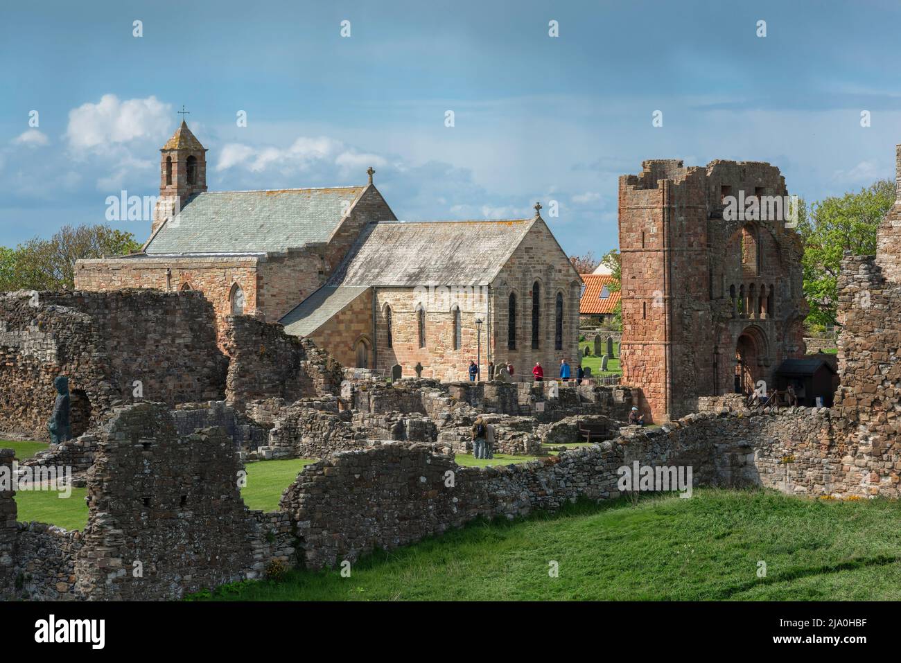 Priory Lindisfarne, Blick auf einen Teil der Ruinen des Priory Lindisfarne mit der Pfarrkirche St. Mary's innerhalb seiner Mauern, Holy Island, Northumberland Stockfoto