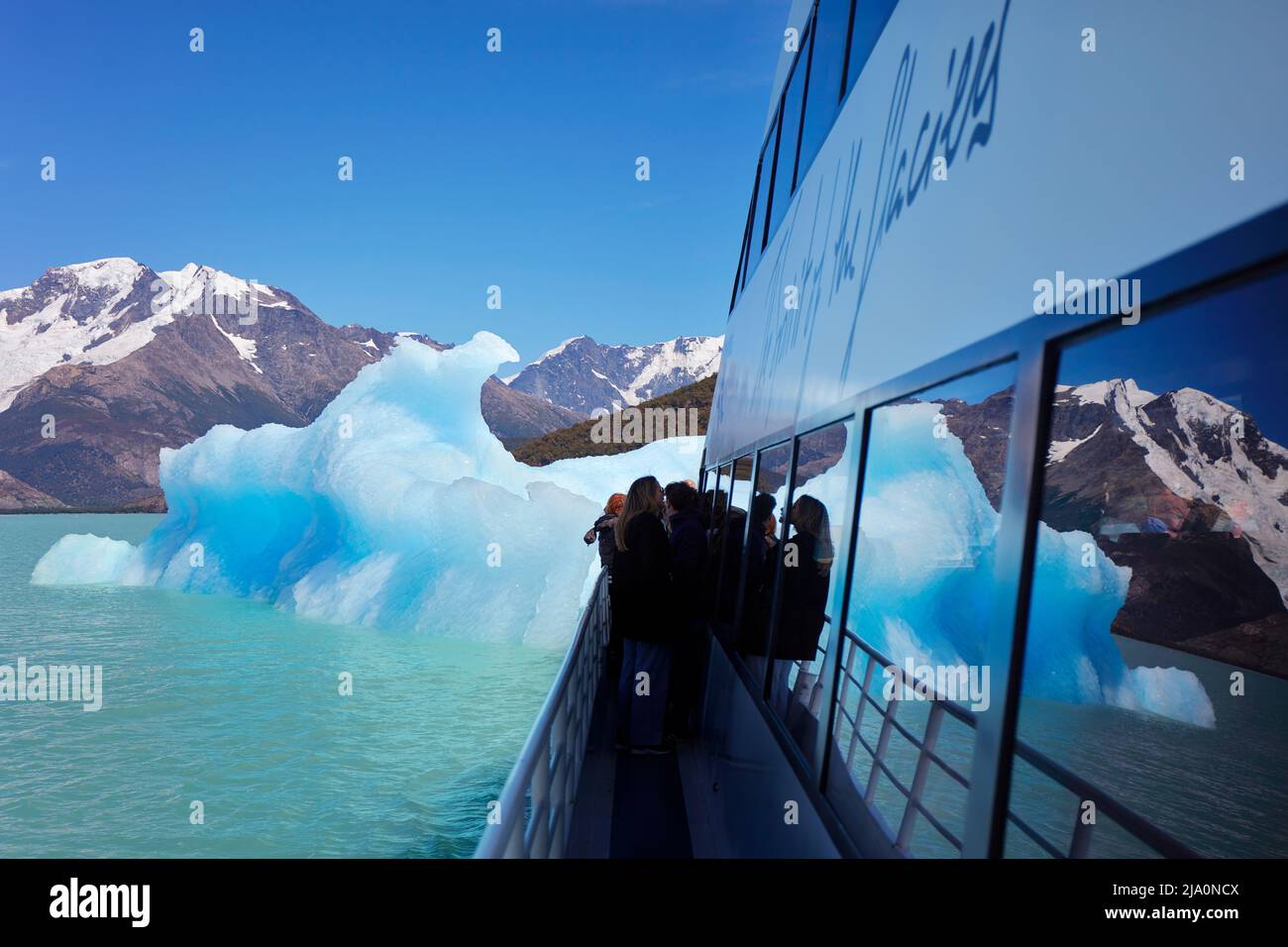 Ein blauer Eisberg, der sich während der Fahrt im Argentino Lake, Los Glaciares National Park, Argentinien, im Schiffsspiegel spiegelt. Stockfoto
