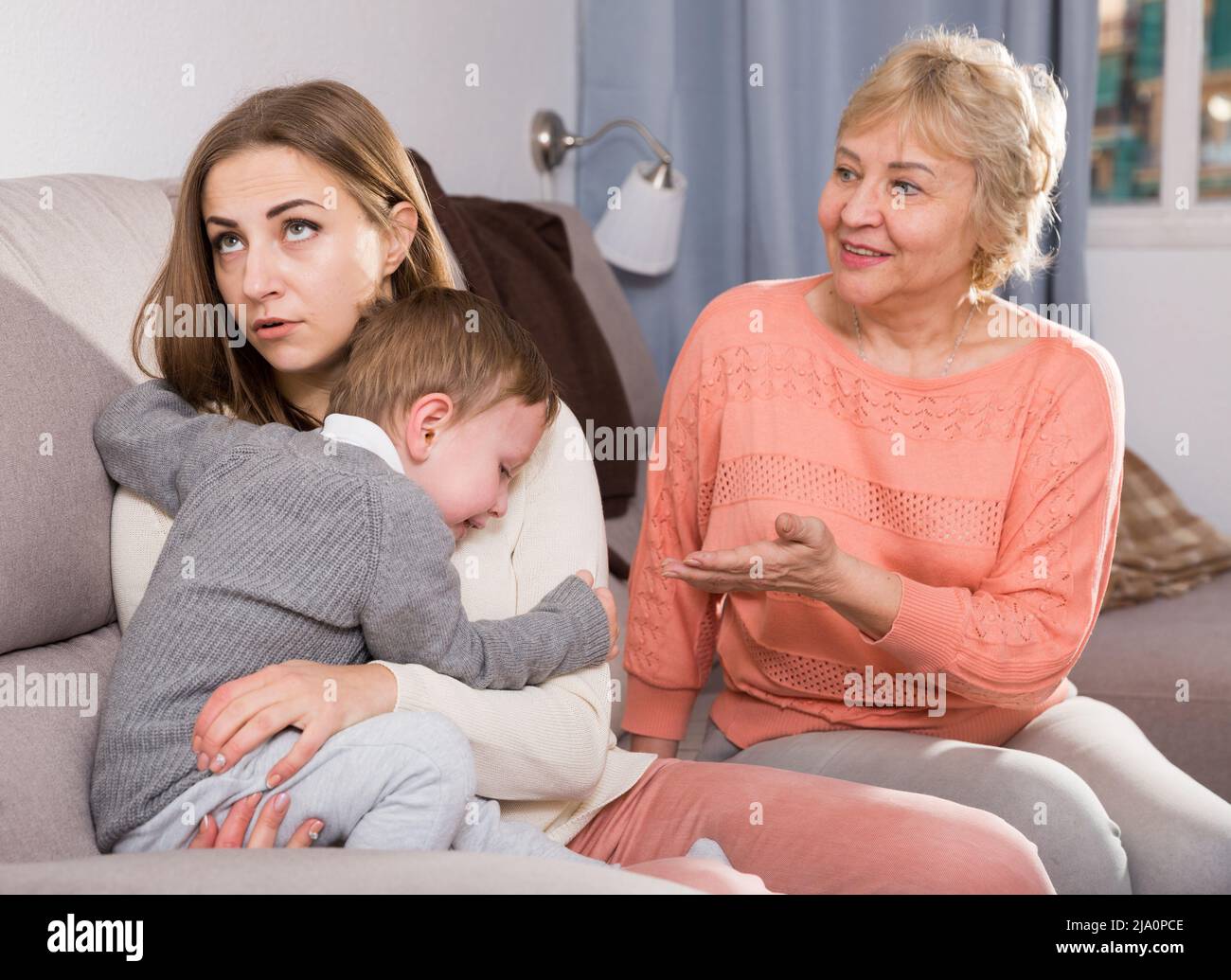 Zwei Erwachsene Frauen haben Meinungsverschiedenheiten mit dem erwachenden Kind Stockfoto