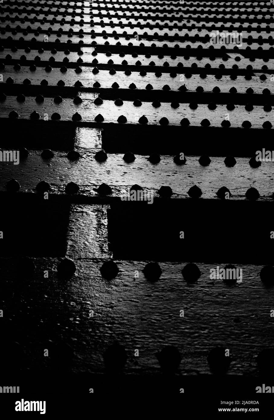 Schwarz und Weiß Abstrakt Schwarz lackierte schmiedeeiserne Metallträger aus genietetem Metall von Under A Bridge in London, Großbritannien Stockfoto