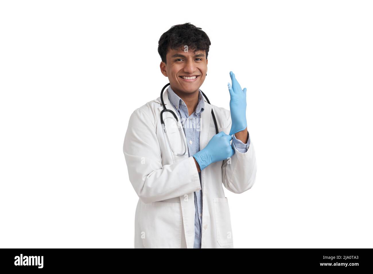 Junger peruanischer Arzt lächelt und trägt blaue Handschuhe, isoliert. Stockfoto