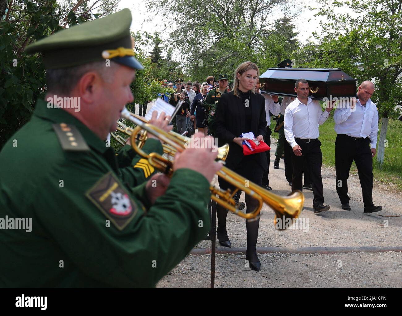 Palmträger tragen den Sarg des russischen Armeesapaters Danil Dumenko, der während des Militärkonflikts in der Ukraine während seiner Beerdigung auf einem Friedhof in Wolzhsky, Russland, am 26. Mai 2022 getötet wurde. REUTERS/REUTERS-FOTOGRAF Stockfoto