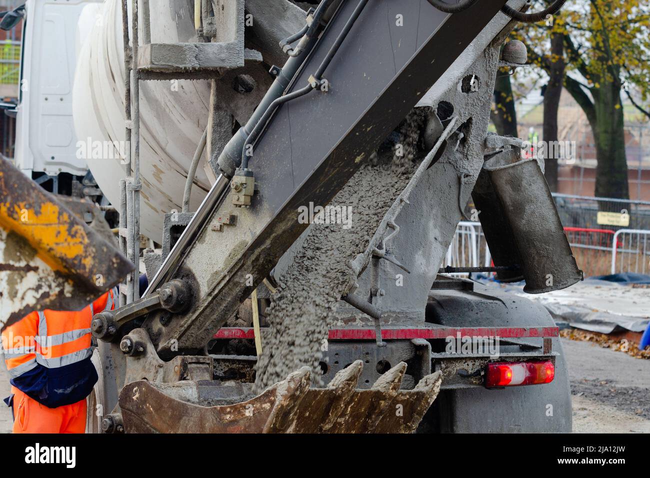 Auf der Baustelle angelieferter und in den Baggereimer legierter Nassbeton Stockfoto