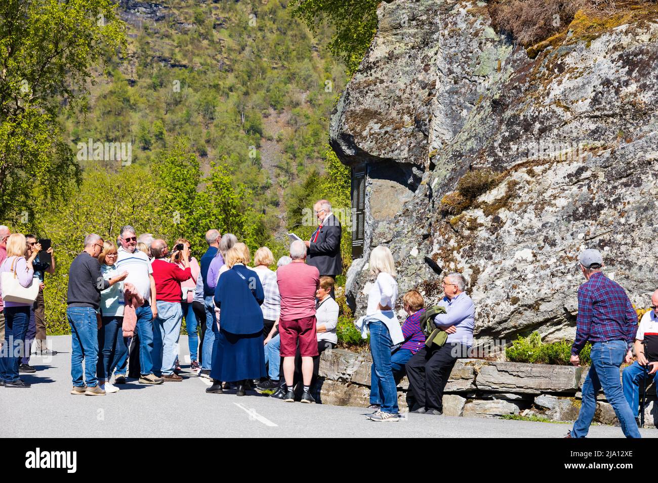 Reiseführer mit Touristen am Denkmal der Tragödie des Ramnefjellet-Steinsturzsturzsturzgefalles von 1905 und 1936. Lake Lovatnet, Loen Norwegen Stockfoto