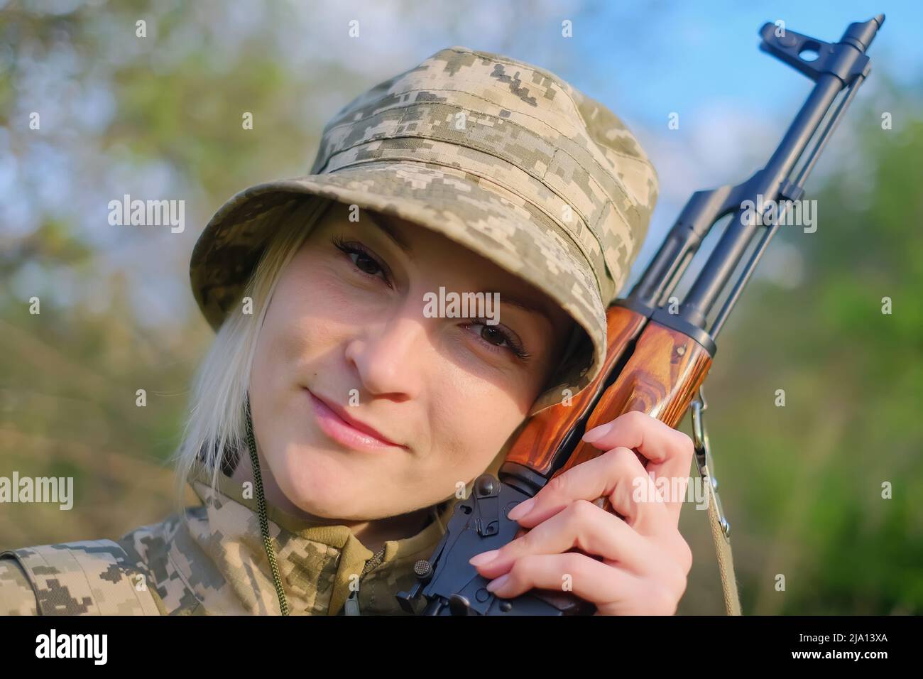 Nahaufnahme eines weiblichen Soldaten mit Waffe, die auf die Kamera schaut Stockfoto