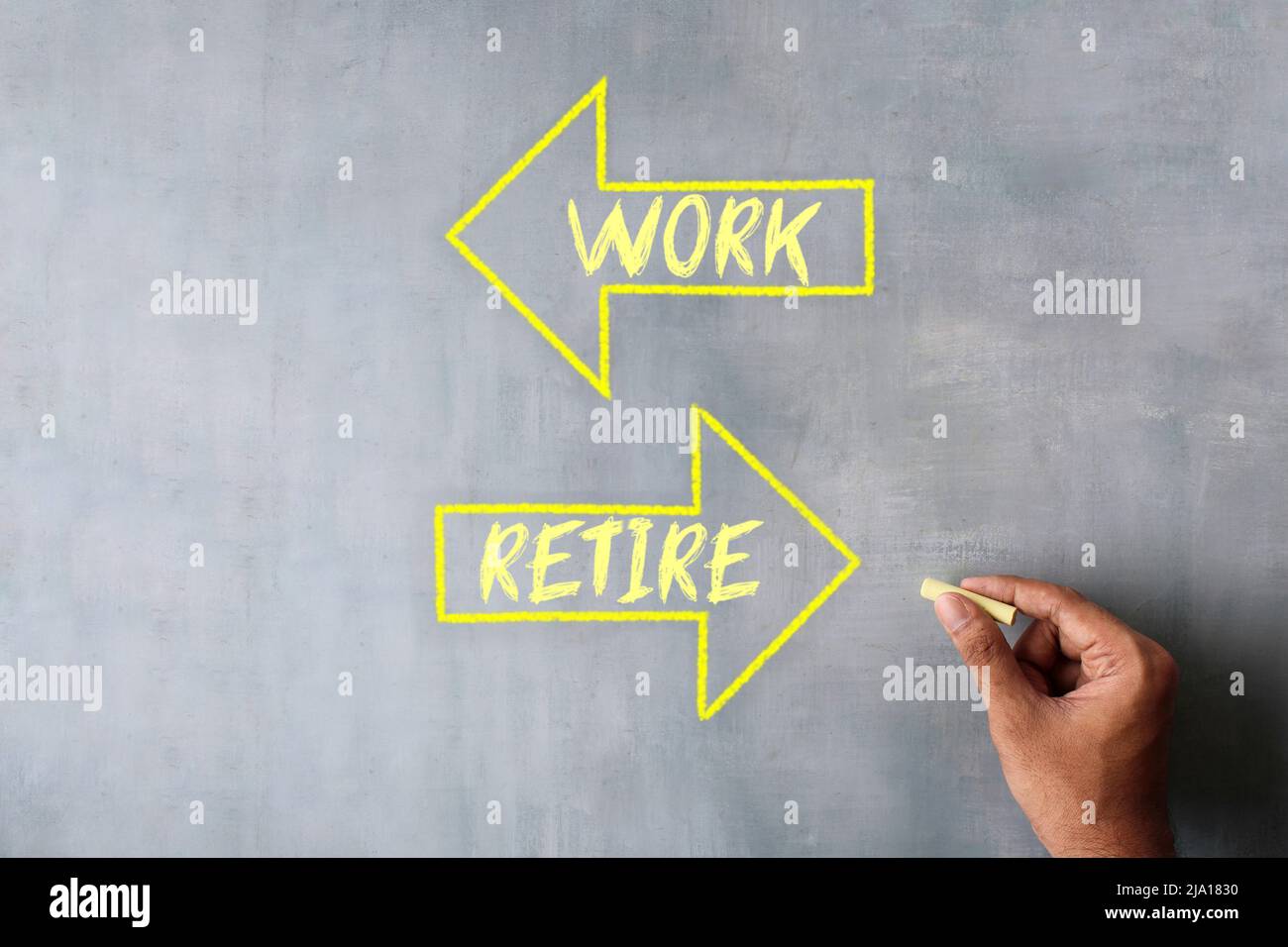 Hand zeichnen Pfeil mit Text ARBEITEN und ZURÜCKZIEHEN mit Kreide. Konzept „Arbeit vs. Ruhestand“ Stockfoto