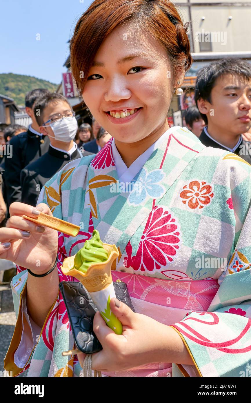 Japan. Kyoto. Higashiyama. Lächelnde Frau im traditionellen Kimono, die ein Eis isst Stockfoto