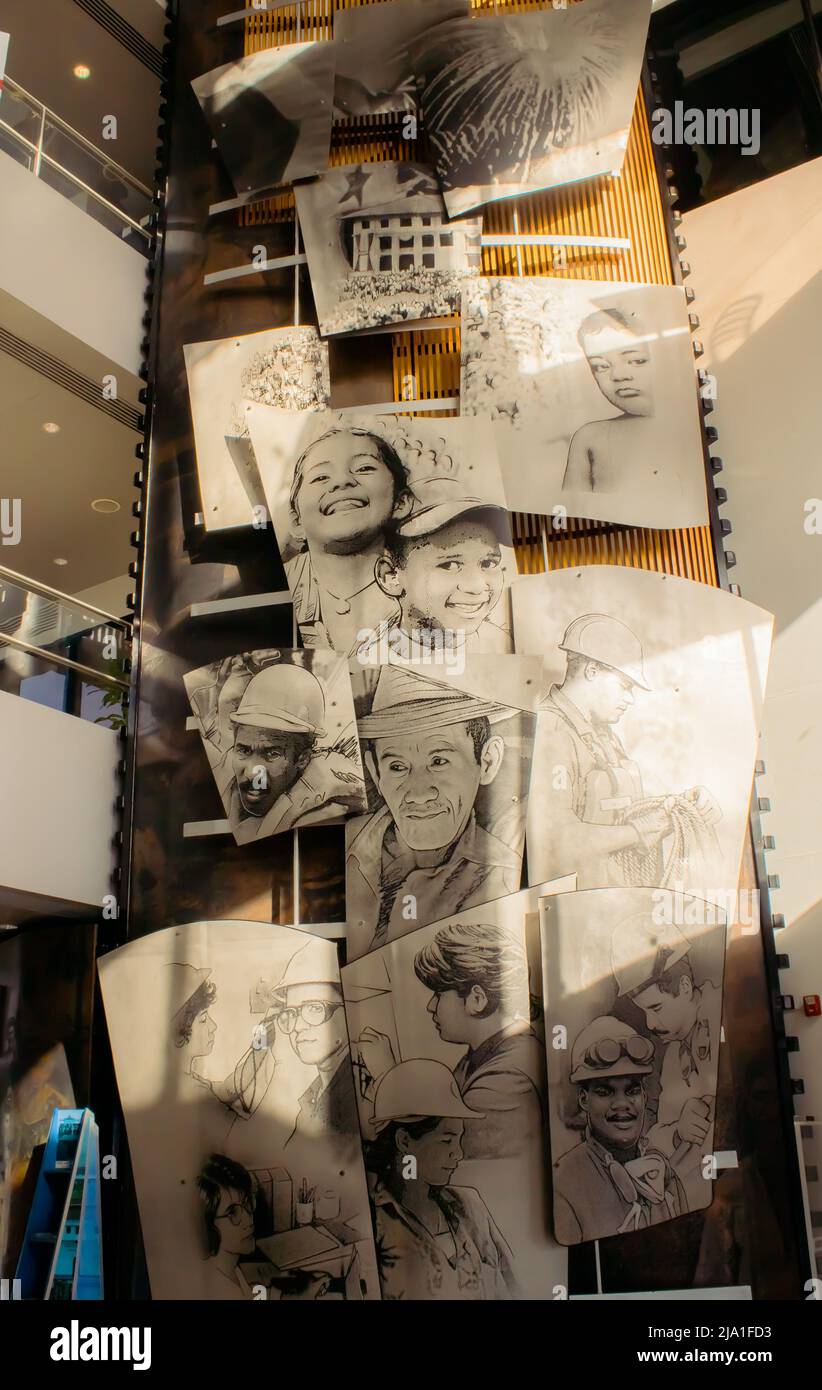 Ein hohes Wandgemälde im Innenbereich, bestehend aus großen, handgezeichneten Schwarzweiß-Porträts, die verschiedene Personen darstellen. Ideal für Themen wie Arbeit, Erbe usw. Stockfoto