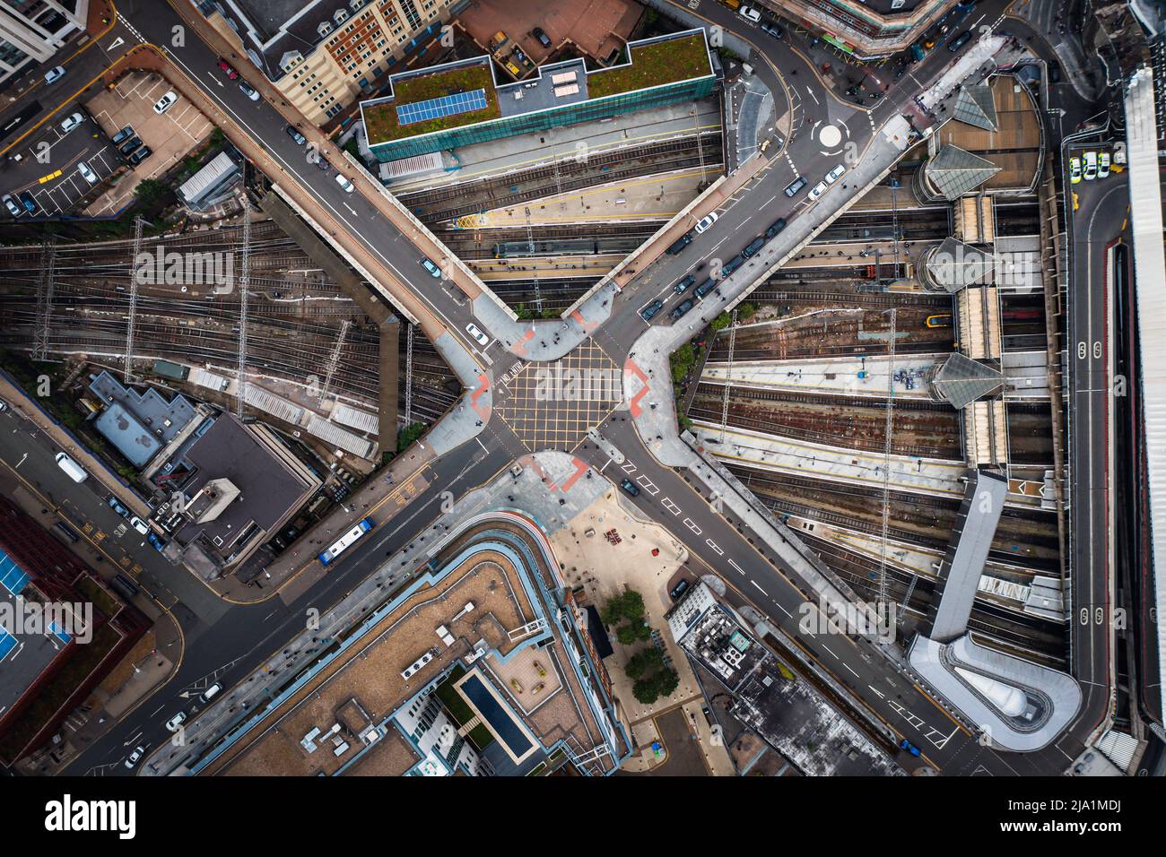 Ein Luftbild direkt über einer städtischen Metropole mit Kreuzung über vielbefahrene Eisenbahn- und U-Bahn-Schienen Stockfoto