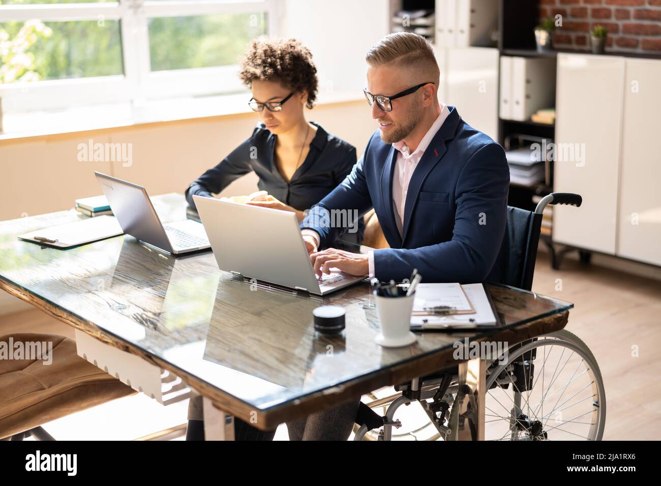 Zwei junge Geschäftsleute Arbeiten am Laptop am Arbeitsplatz Stockfoto
