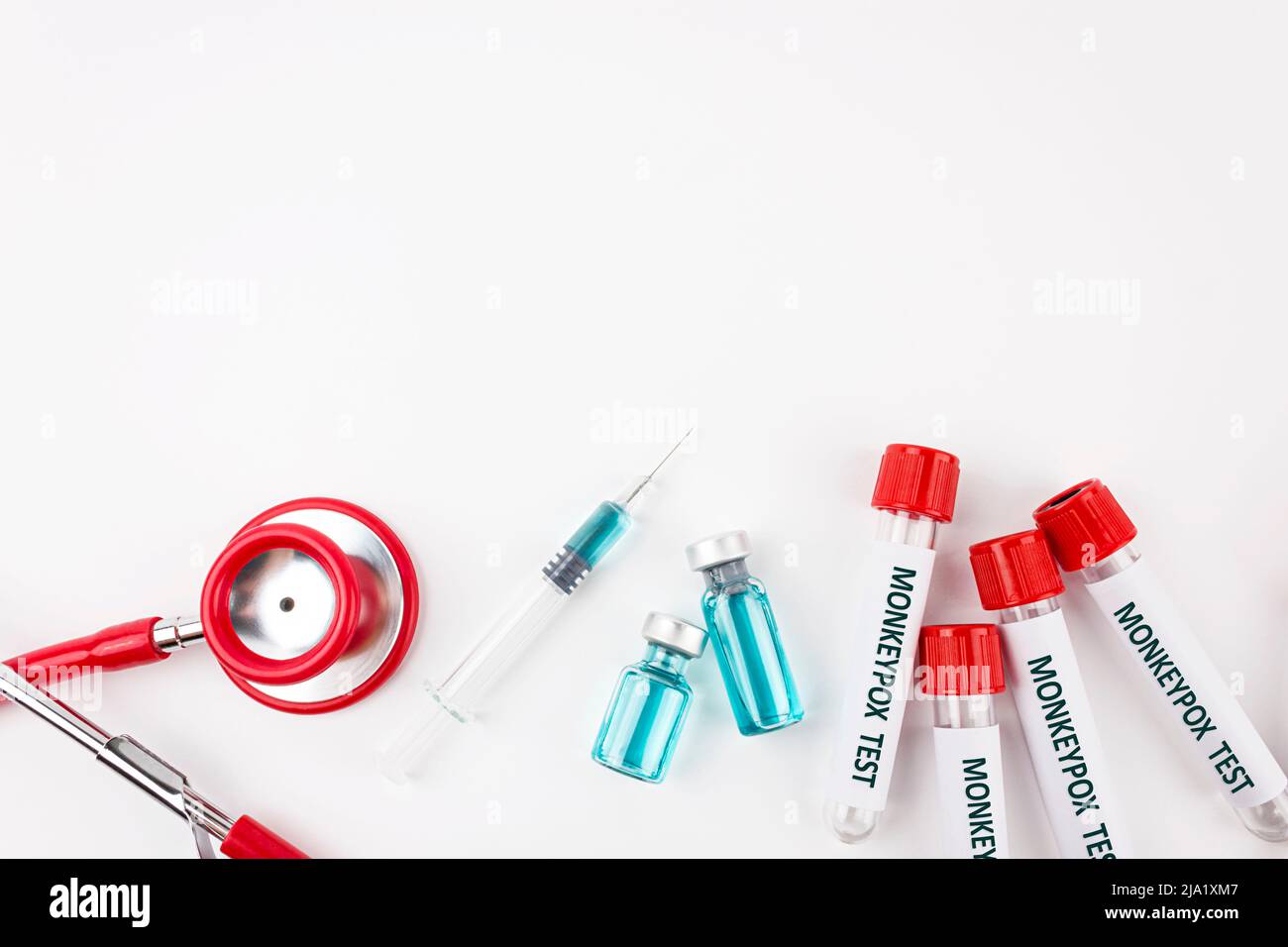 Blutprobenschlauch für Monkeypox-Virustest, Stethoskop und Spritze mit Impfstoffform Pocken auf weißem Hintergrund. Medizinisches Konzept. Draufsicht. Stockfoto