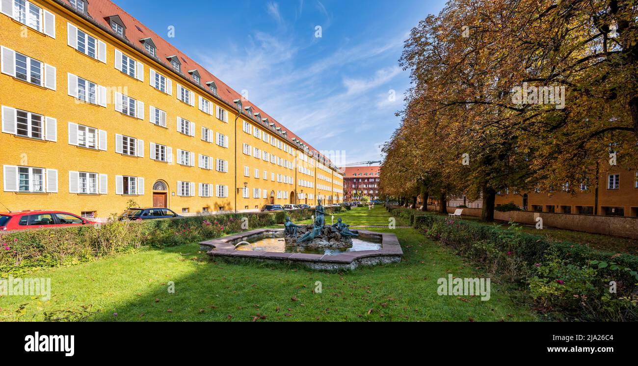 Innenhof mit Park und gelben Mehrfamilienhäusern, Borstei, denkmalgeschützte Wohnsiedlung, Stadtteil Moosach, München, Bayern, Deutschland Stockfoto