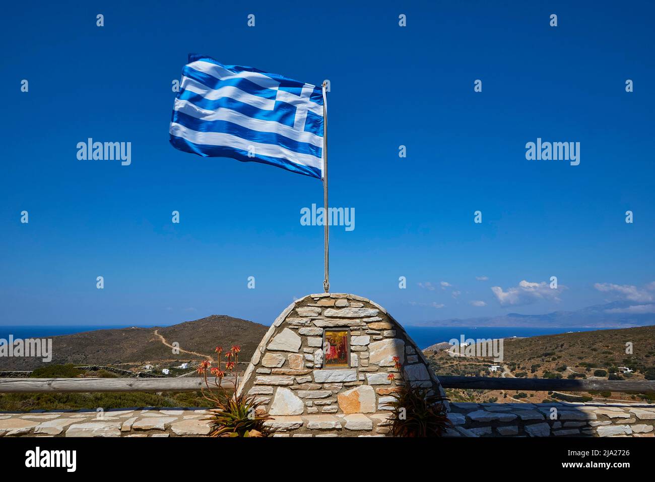 Griechische Nationalflagge im Wind, Kirche, nördlich von Andros, I. N. Evanggelistrias, Kapelle, kirche Evanggelistrias, blauer Himmel, grau-weiße Wolken Stockfoto