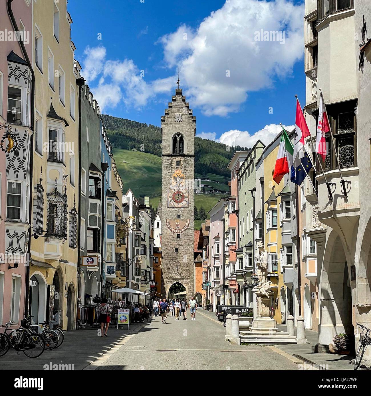 Blick auf den Zwölften Turm in der historischen Neustadt Sterzing, im Vordergrund St.-Johannes-Nepomuk-Brunnen, darüber die italienische Nationalflagge, Flagge Stockfoto