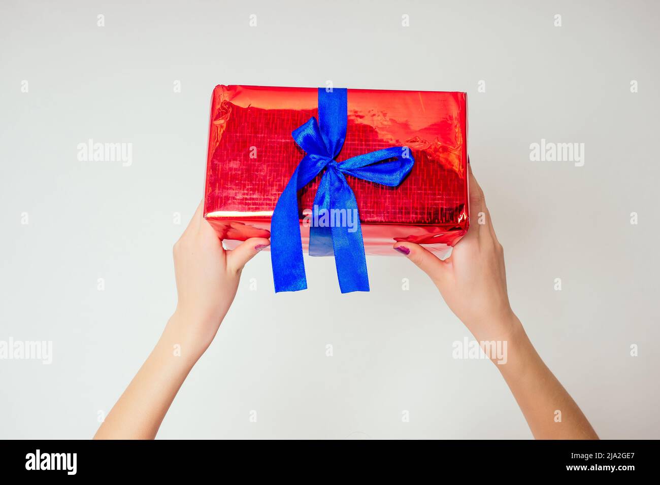 Nettes kleines Mädchen hält Helium blau, gelb und Gold Ballons und eine Box mit einem Geschenk Happy Birthday auf weißem Hintergrund im Studio .christmas und neu Stockfoto