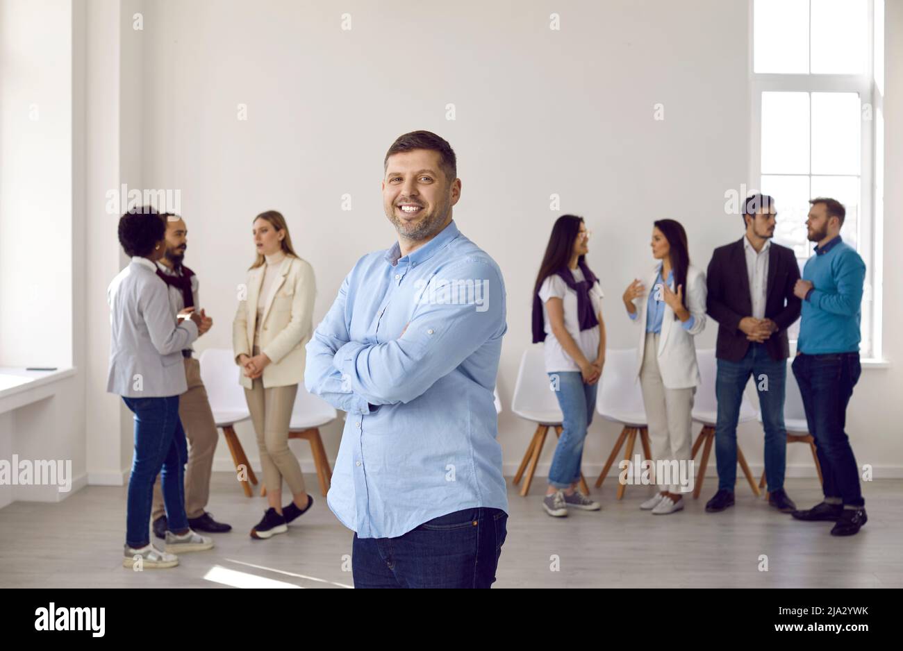 Porträt eines lächelnden Geschäftsmannes, der im Büro posiert Stockfoto