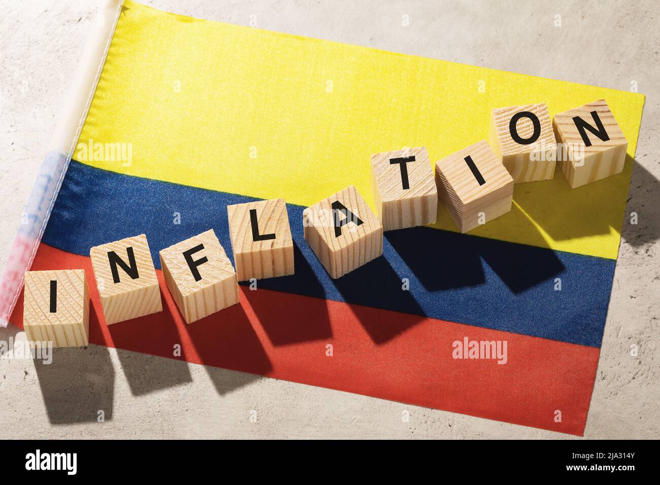 Flagge Kolumbiens und Holzwürfel mit Text, ein Konzept zum Thema Inflation im Land Stockfoto