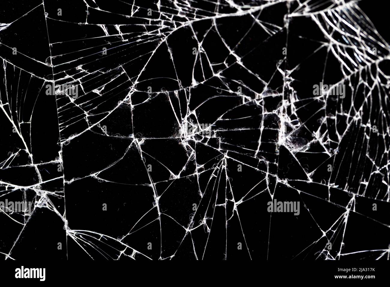 Altes schmutziges Glas mit vielen Rissen, altes zerbrochenes Glas auf schwarzem Hintergrund Stockfoto