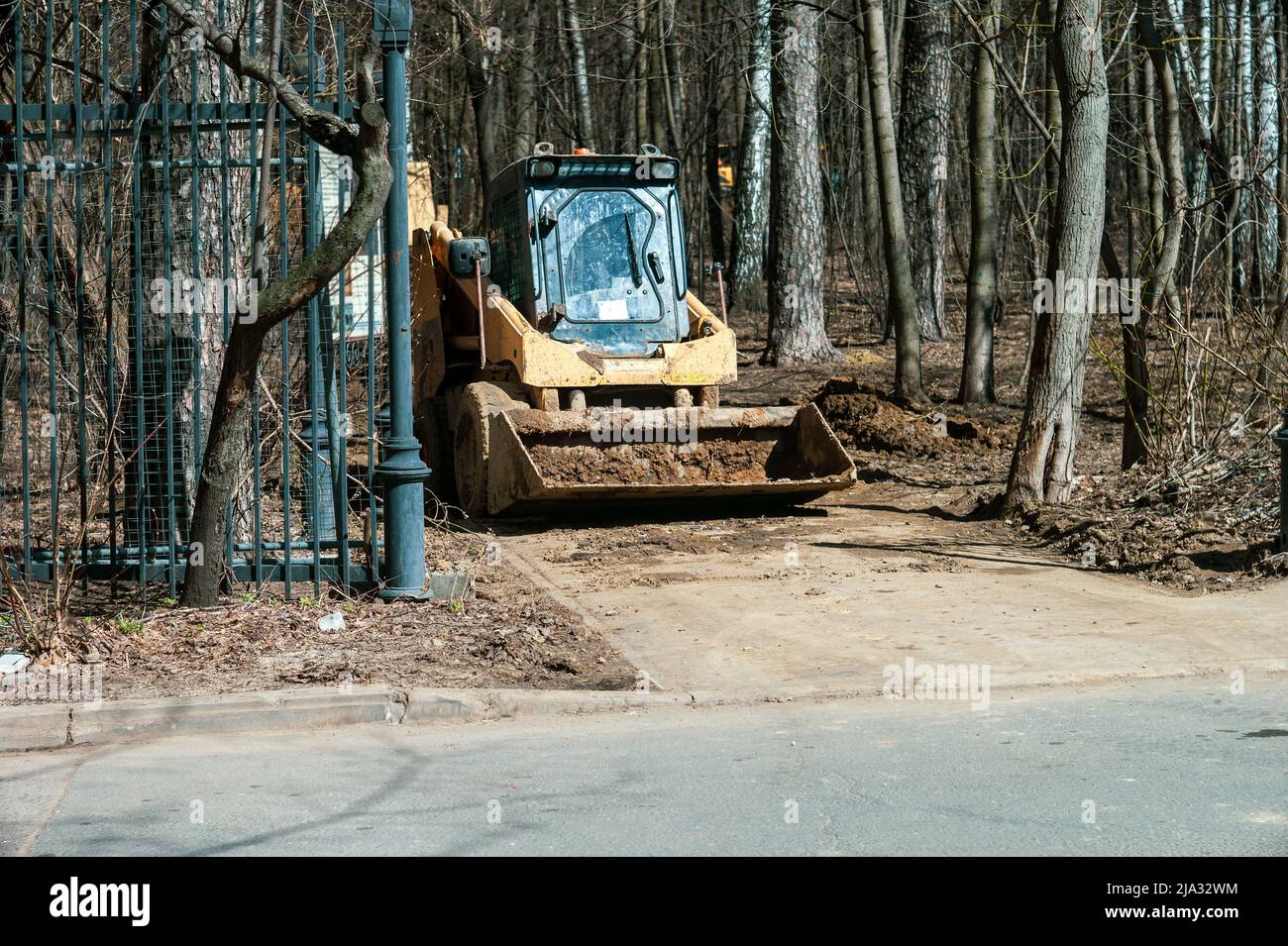 Ein Bulldozer und Ausgrabungen arbeiten in einem Park, sonnige Tagesaufnahme Stockfoto