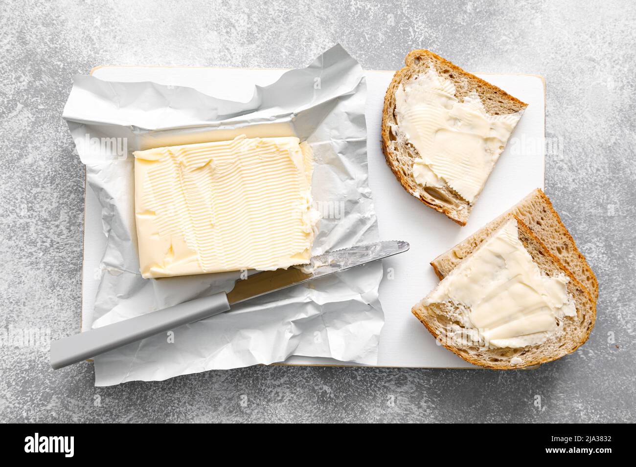 Butterblock mit Buttermesser in offener Packung. Butterbrot Stockfoto