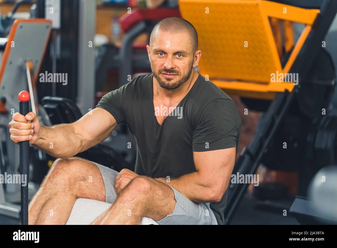 Porträt eines muskulösen Mannes, der im Fitnessstudio trampt und die Kamera anschaut. Hochwertige Fotos Stockfoto