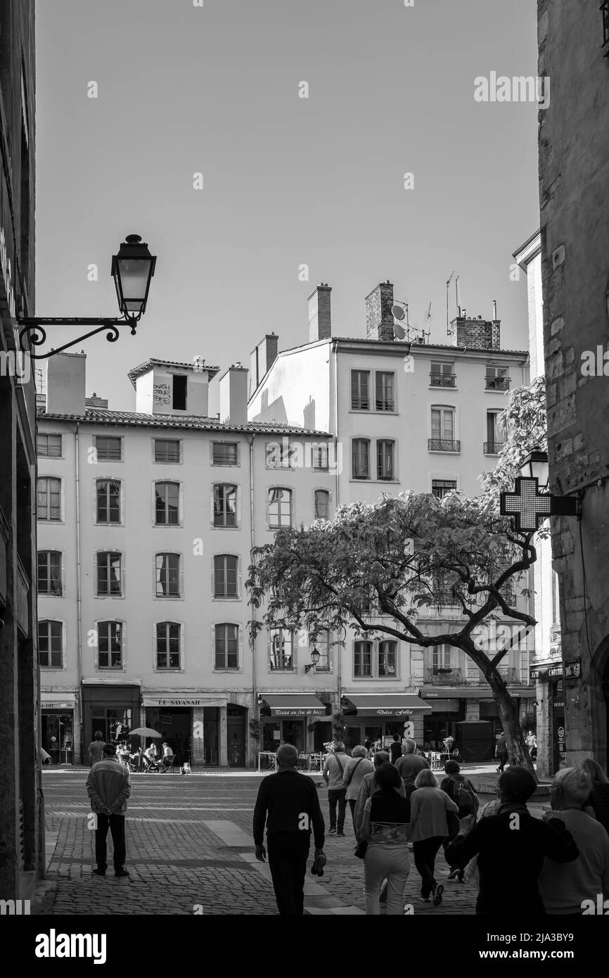 Lyon, Frankreich - 9. Mai 2022 : Blick auf Touristen, die in der malerischen Altstadt von Lyon in Schwarz-Weiß spazieren Stockfoto