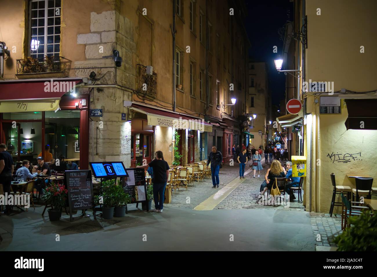 Lyon, Frankreich - 10. Mai 2022 : Touristen, die in Restaurants im Freien essen und andere, die nachts durch die Altstadt von Lyon fahren Stockfoto