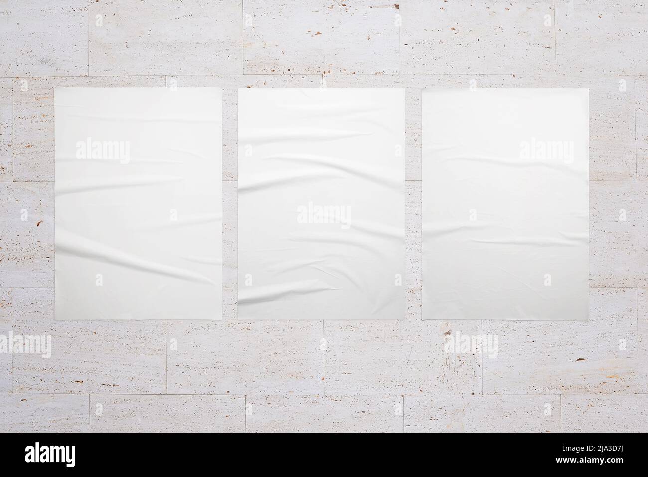 Drei weiße Poster an der Innenwand. Weiße, leere, zerknitterte Textur für die Designpräsentation Stockfoto