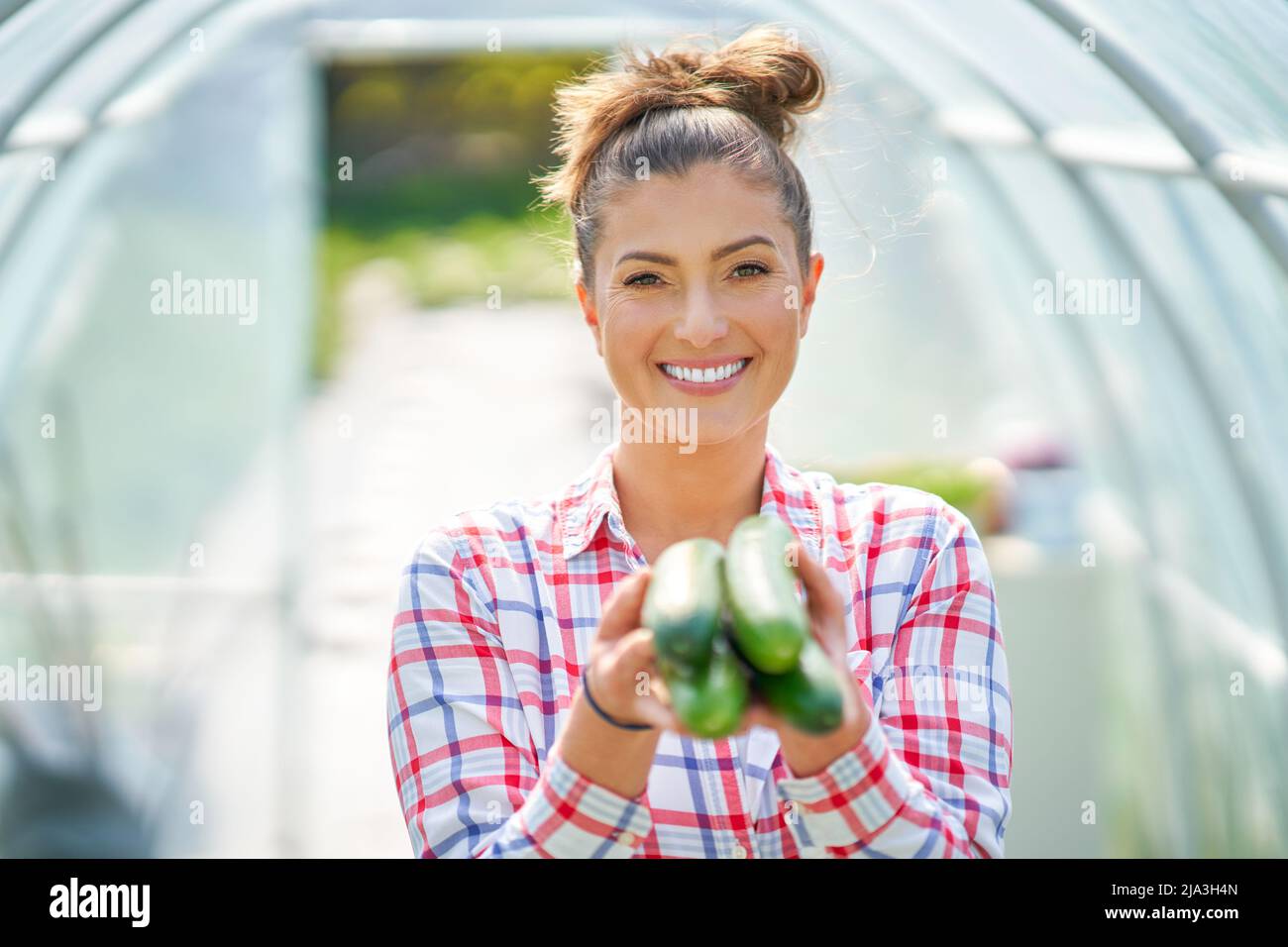 Bild einer jungen Gärtnerin mit Gurke Stockfoto