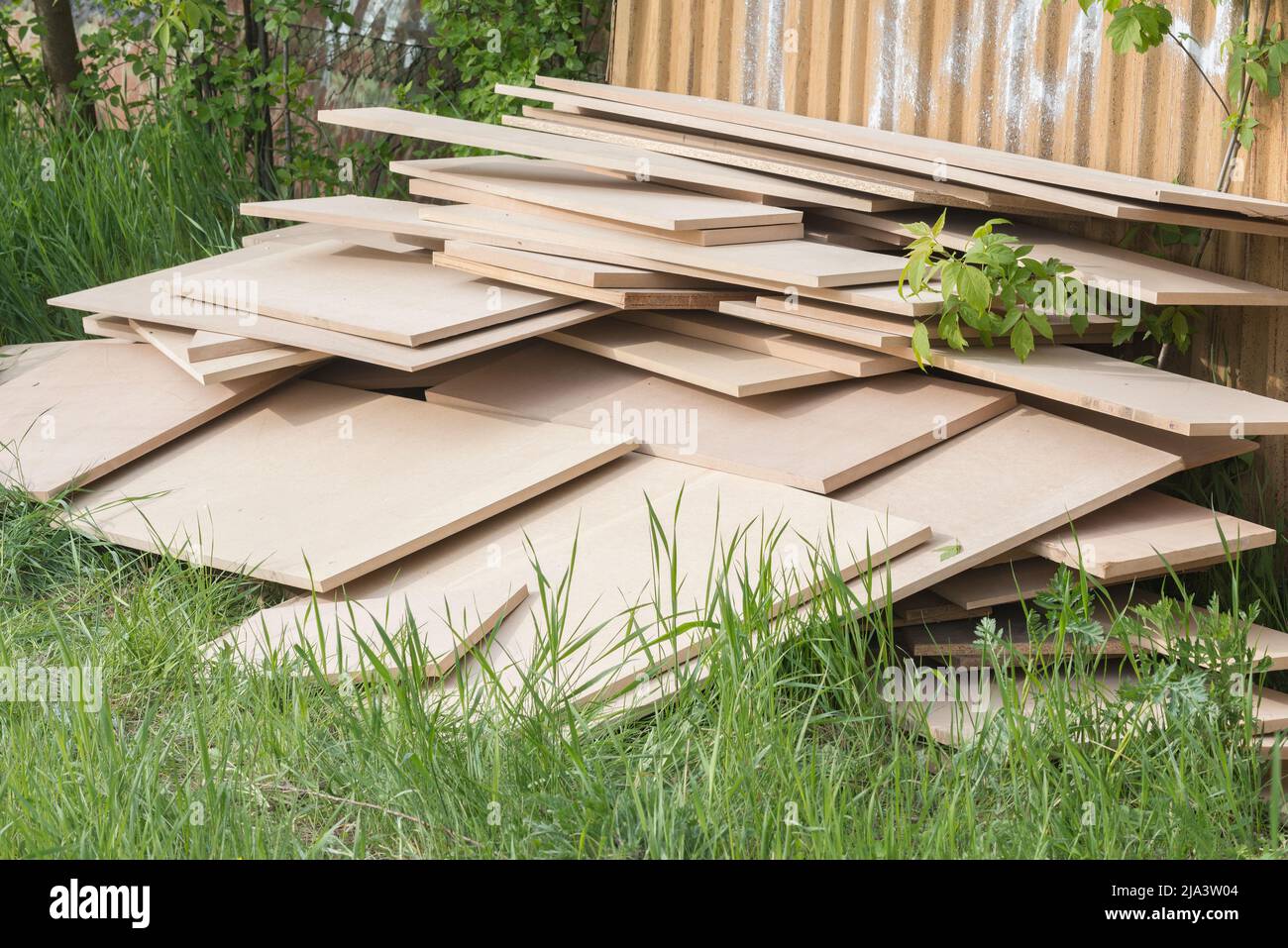 Stapel von Brettern am Metallzaun. Stockfoto
