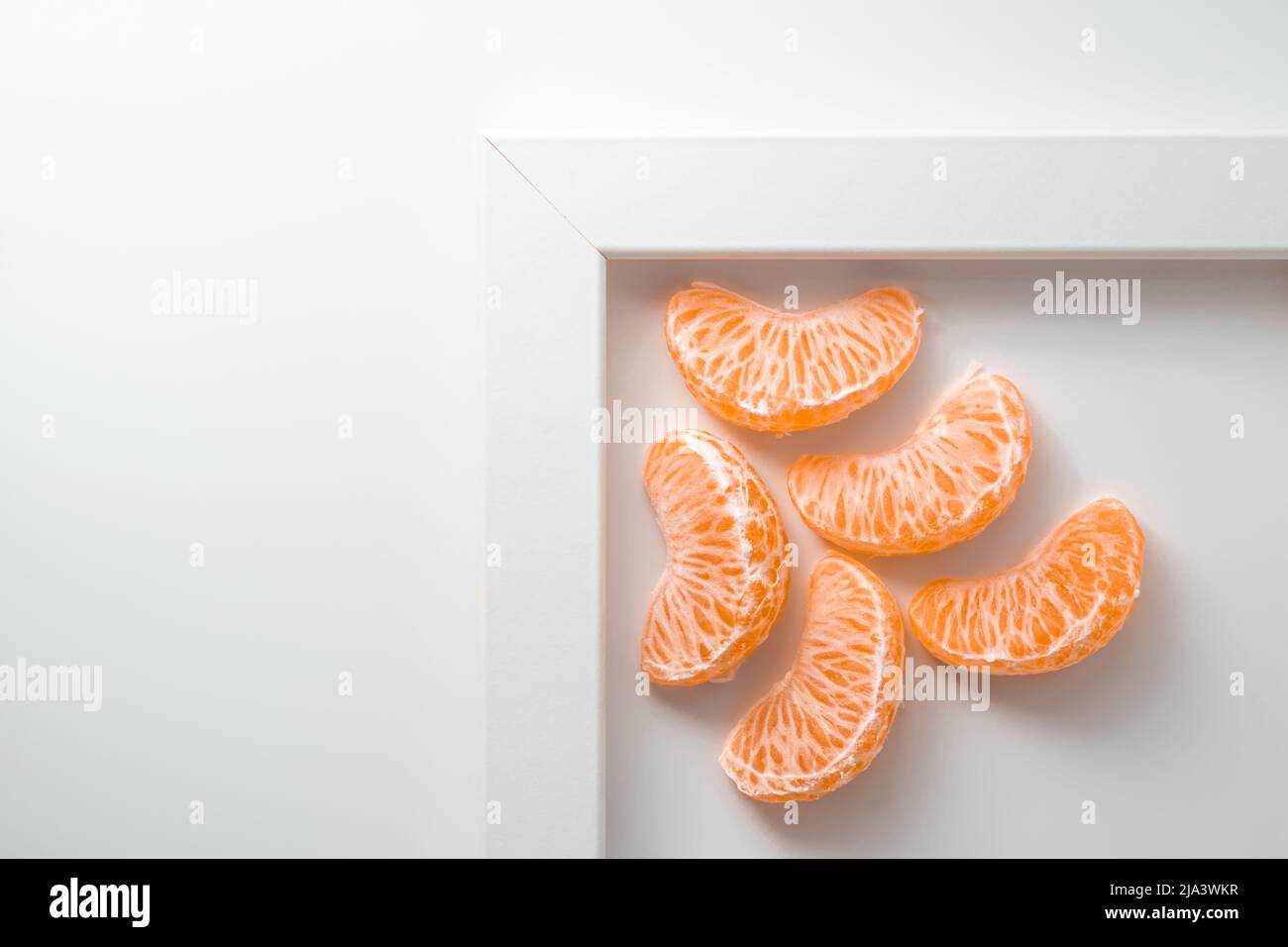 Fünf Clementine-Tangerine-Segmente in der weißen Draufsicht mit Platz für Text. 5 Mandarin-Stücke Stockfoto