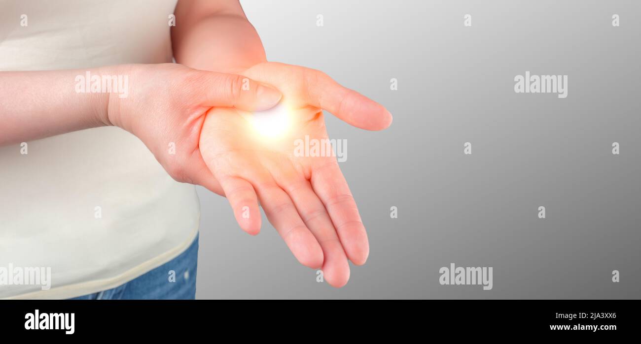 Schmerzen am Handgelenk. Karpaltunnelsyndrom, Arthritis, neurologisches Krankheitskonzept. Taubheit der Hand. Nahaufnahme einer jungen Frau mit Schmerzen auf der Hand auf grauem b Stockfoto