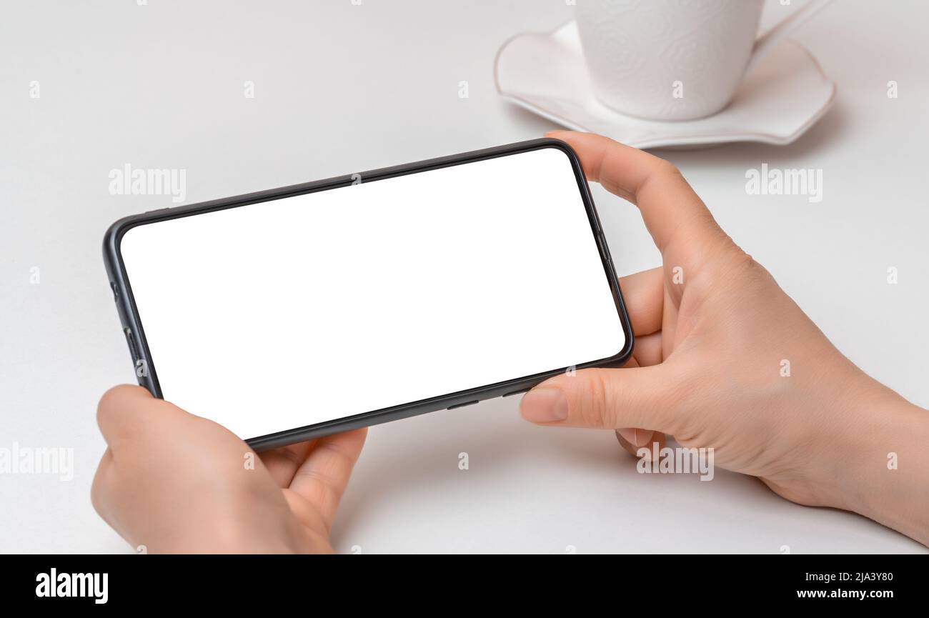 Abgeschnittene Ansicht der Frau Hände halten Handy mit leerem Copy Space Bildschirm für SMS oder Informationsinhalt, weibliche Textnachricht lesen o Stockfoto