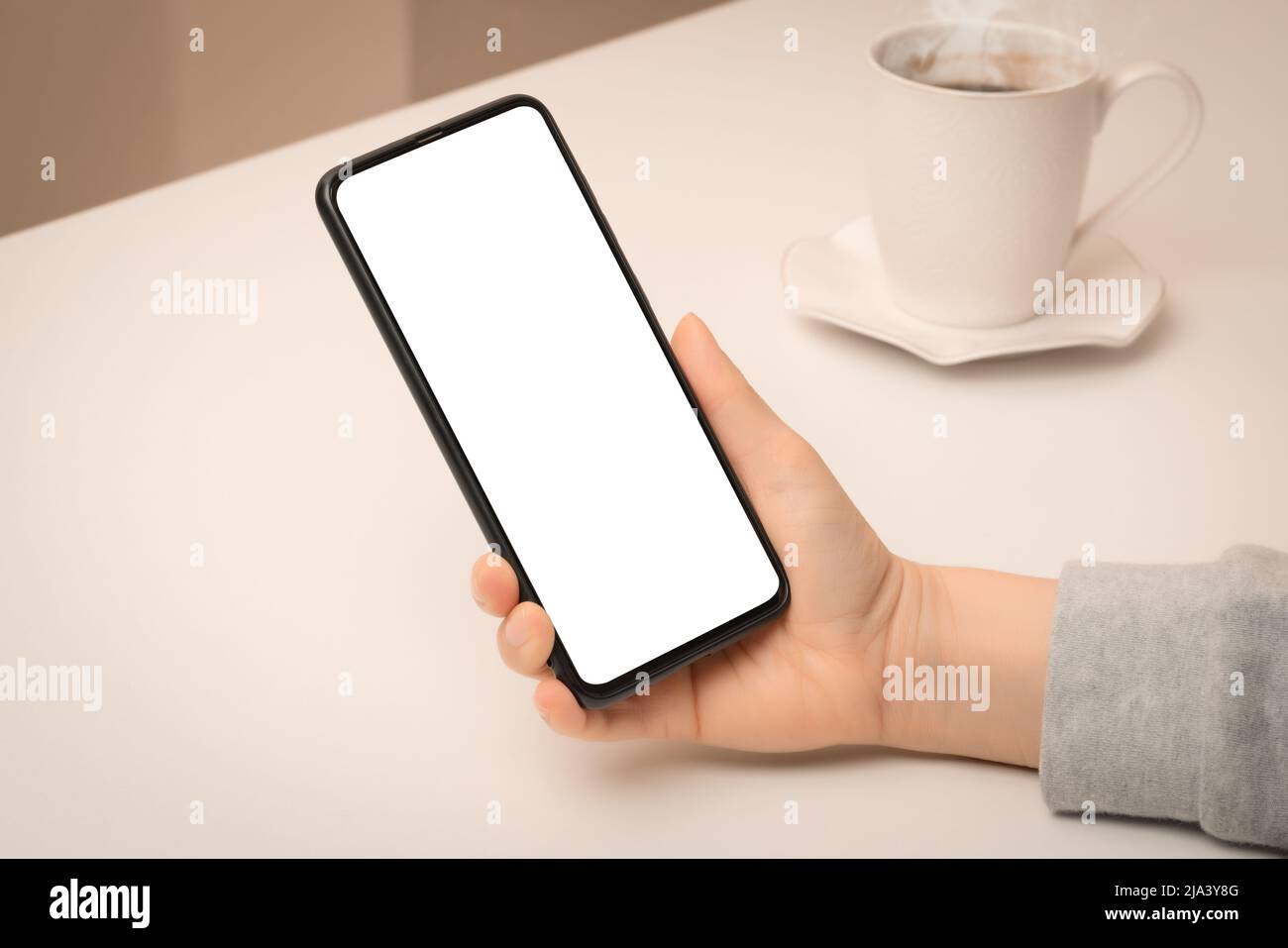 Modup-Telefon. Nahaufnahme Hand hält Handy Smartphone mit leerem Bildschirm im Café. Frau Hand mit imitierten Smartphone im Café Stockfoto